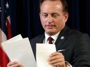 FILE - In this Dec. 19, 2016, file photo, Iowa Secretary of State Paul Pate collects ballots during Iowa's Electoral College vote at the Statehouse in Des Moines, Iowa. Nearly 1 percent of voters in Iowa's largest counties did not show identifications during the June 5 primary, an early sign that the new voter ID law could have some impact when it takes full effect next year. As part of a gradual rollout of the ID requirements, voters without them in 2018 are being allowed to sign an "Oath of Identification" attesting that they are who they say they are. Pate has argued that the identification requirements will improve the integrity of elections.