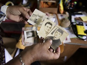 Nerybelle Perez holds several pictures of her father, World War II veteran Efrain Perez, who died inside an ambulance after being turned away from the largest public hospital when it had no electricity or water, days after Hurricane Maria passed, in Guaynabo, Puerto Rico, Thursday, June 7, 2018. The Puerto Rican government says it believes more than 64 died as a result of the storm but it will not raise its official toll until George Washington University completes a study of the same data being carried out on behalf of the U.S. territory.
