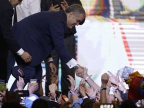 Colombia's President Elect Ivan Duque shakes hands with supporters after his victory in the presidential runoff election in Bogota, Colombia, Sunday, June 17, 2018. Duque defeated Gustavo Petro, a former leftist rebel and ex-Bogota mayor.