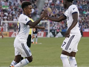 Vancouver Whitecaps forward Yordi Reyna (29) celebrates his goal against the Colorado Rapids with teammate Alphonso Davies (67) during the first half of an MLS soccer match Friday, June 1, 2018, in Commerce City, Colo.