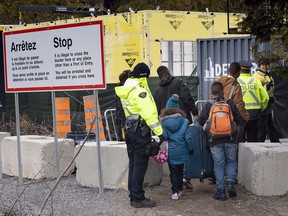 A family of asylum seekers, claiming to be from Colombia, is arrested by RCMP officers as they cross the border into Canada from the United States on April 18, 2018, near Champlain, NY.