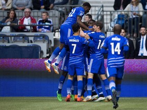 FC Edmonton's Tomi Ameobi is mobbed by his teammates after scoring against the Vancouver Whitecaps during the first half of a Canadian Championship semifinal soccer game in Vancouver, B.C., on Wednesday May 13, 2015. FC Edmonton, which shuttered its NASL pro franchise last November, announces details of its move to the new Canadian Premier League.