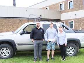 Kevin Mitchell, the general manager of Twin Motors, student Zach Zurba, and Patty Goodine, a teacher and the attendance committee chair at Dauphin Regional Comprehensive Secondary School pose outside the school with a truck in Dauphin, Man., in this recent handout photo. Students at a Manitoba high school have a major incentive to show up to class - they could start their summer driving a truck. Grade 10 student Zach Zurba took home a 2004 Chevy Avalanche truck donated by Twin Motors on Friday.