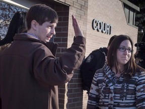 Edouard Maurice, left, waves to supporters outside court with his wife Jessica, right, in Okotoks, Alta., Friday, March 9, 2018. All charges against a man accused of firing shots during a confrontation on his property in southern Alberta have been dropped.