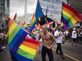 People take part in the Pride parade in Toronto, Sunday, June 25, 2017. Toronto's unabashedly in-your-face celebration of everything LGBTQ is set to take place on Sunday against a backdrop of nasty recriminations involving the community, police and black citizens, and the sobering reality of a man charged with killing eight people, most of whom frequented the city's gay district.