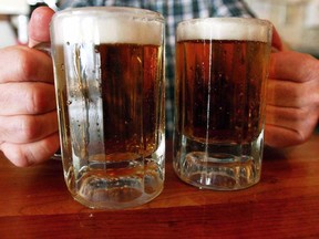 A bartender serves two mugs of beer at a tavern in Montpelier, Vt. The Canadian Food Inspection Agency is holding consultations over the summer about an updated Canadian definition of beer - what can go in it, sugar content - and new labelling rules for brewers.