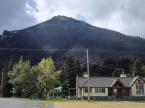 Houses are dwarfed by a burned mountainside in Waterton Lakes, Alta., Wednesday, Sept. 20, 2017.