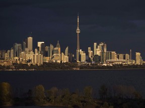 Light from the sunset hits the skyline in Toronto, on Tuesday October 31, 2017.