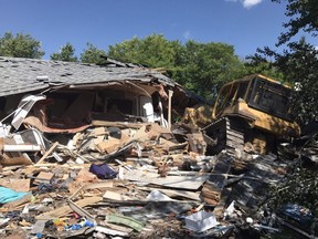 A bulldozer sits on top of debris from a house in Yorkton, Sask. in this undated handout photo. A Saskatchewan man who bulldozed a house with two people inside, including his son's wife, has been sentenced to 5 1/2 years in prison after pleading guilty to attempted murder.