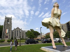 This Thursday, June 7, 2018 photo shows  Seward Johnson's "Forever Marilyn" sculpture in Latham Park in Stamford, Conn.  The 26-foot statue that was newly installed in the park is scandalizing some because her rear end is facing the entrance of the First Congregational Church.