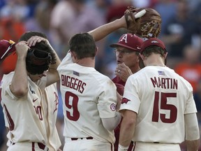 Arkansas coach Dave Van Horn, center, talks to players on the mount as he changes pitchers during the fifth inning against Oregon State in Game 3 of the NCAA College World Series baseball finals in Omaha, Neb., Thursday, June 28, 2018.