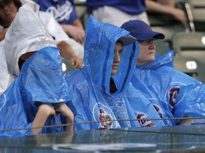 Chicago Cubs fans sit through a rain delay before a baseball game between the Cubs and Los Angeles Dodgers Monday, June 18, 2018, in Chicago.