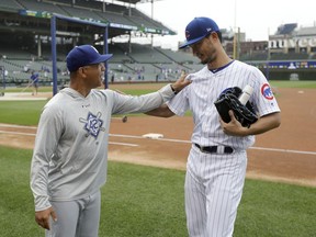 Los Angeles Dodgers manager Dave Roberts, left, talks with former player Chicago Cubs starting pitcher Yu Darvish, after Darvish pitched a simulated game before a baseball game between the two clubs Wednesday, June 20, 2018, in Chicago.