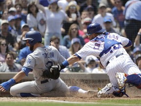 Chicago Cubs catcher Willson Contreras tags out Los Angeles Dodgers' Chris Taylor at home off a throw from right fielder Jason Heyward, to end the top half of the third inning of a baseball game Wednesday, June 20, 2018, in Chicago.