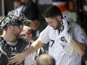 Chicago White Sox starting pitcher Lucas Giolito, right, pats catcher Kevan Smith on the chest after the top half of the first inning of a baseball game against the Minnesota Twins Thursday, June 28, 2018, in Chicago.