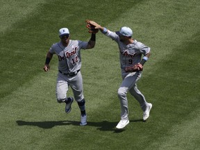 Detroit Tigers center fielder Leonys Martin, left, celebrates with right fielder Nick Castellanos after catching a fly ball by Chicago White Sox's Tim Anderson during the fifth inning of a baseball game in Chicago, Sunday, June 17, 2018.