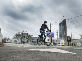 A cyclist rides across Toronto’s Lakeshore Blvd at Parliament Street,  the proposed location for Google's Sidewalk Labs Plan, Tuesday January 23, 2018. Police in Toronto say a 13-year-old boy is facing a murder charge after a cyclist was allegedly run down with a car and assaulted.