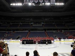The Washington Capitals NHL hockey team pose for a team picture with the Stanley Cup on the ice at Capital One Arena, Tuesday, June 12, 2018, in Washington.