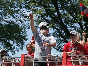 Washington Capitals coach Barry Trotz tosses a strand of beads during a victory parade for the NHL hockey Stanley Cup champions Tuesday, June 12, 2018, in Washington.