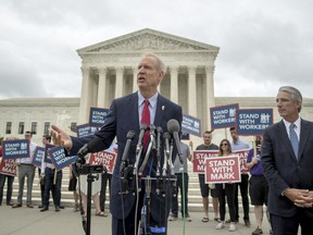 Illinois Gov. Bruce Rauner, center, accompanied by Liberty Justice Center founder and chairman John Tillman, right, speaks outside the Supreme Court after the court rules in a setback for organized labor that states can't force government workers to pay union fees, at the Supreme Court in Washington, Wednesday, June 27, 2018.