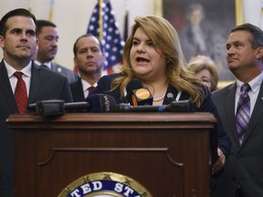 Puerto Rico's Resident Commissioner, Jenniffer González-Colón, speaks during a ceremony on Capitol Hill in Washington, Wednesday, June 27, 2018, to present the Puerto Rico Admission Act of 2018, a bill to chart Puerto Rico's transition from a territory to a State of the Union. She is joined by Puerto Rico Gov. Ricardo Rosselló, left, Rep. Don Bacon, R-Neb., right, and others