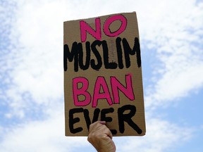 A protester holds up a sign that reads "No Muslim Ban Ever" as he protests against the Supreme Court ruling upholding President Donald Trump's travel ban outside the the Supreme Court in Washington, Tuesday, June 26, 2018.