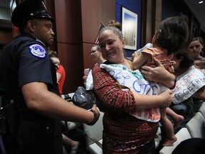 Lucy Martin and her daughter Branwen Espinal, together with other mothers and their babies, are removed from the hearing floor after babies started crying, during a House Committee on the Judiciary and House Committee on Oversight and Government Reform hearing, on Capitol Hill in Washington, Tuesday, June 19, 2018. The mothers were protesting the forced separation of migrant children from their parents. Martin is married to a Honduran.