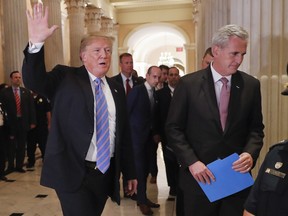 President Donald Trump, left, gestures as he walks with House Majority Leader Kevin McCarthy of Calif., right, while leaving the U.S. Capitol in Washington after meeting with GOP leadership, Tuesday, June 19, 2018. Walking behind them is Stephen Miller, center, White House senior adviser.