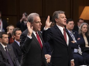 Justice Department Inspector General Michael Horowitz, left, and FBI Director Christopher Wray are sworn in to testify as the Senate Judiciary Committee examines the internal report of the FBI's Clinton email probe and the role of former FBI Director James Comey's actions during the 2016 presidential campaign, on Capitol Hill in Washington, Monday, June 18, 2018.
