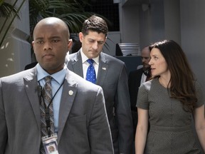 Speaker of the House Paul Ryan, R-Wis., confers with his press secretary AshLee Strong, right, as a member of his protection detail escorts at left, following a closed-door GOP strategy session at the Capitol in Washington, Tuesday, June 26, 2018. Ryan has scheduled a long-awaited showdown vote on a broad Republican immigration bill for Wednesday, but he's showing little confidence that the package will survive.