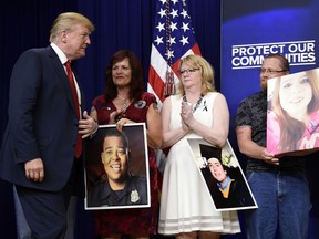 President Donald Trump, left, arrives for an event on the White House complex in Washington, Friday, June 22, 2018, with people who have lost family members from crime committed by undocumented immigrants.
