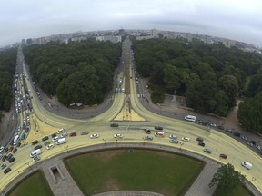 The roundabout at Berlin's landmark Victory Column is poured by thousands of liters of yellow paint, delivers by Greenpeace activists as a protest to promote solar power over coal, in Berlin, Tuesday, June 26, 2018.