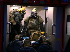 German police officers in protective gear enters a rescue car during an operation in Cologne, Germany, late Tuesday June 12, 2018. German police are searching the apartment of a 29-year-old Tunisian man who is accused of keeping toxic substances in his home.