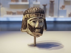 This Monday, June 4, 2018 photo shows a detailed figurine of a king's head on display at the Israel Museum, dating to biblical times, and found last year near Israel's northern border with Lebanon, in Jerusalem. A palm-sized enigmatic sculpture of a king's head dating back nearly 3,000 years has set off a modern-day mystery caper as scholars try to figure out whose face it depicts. The 5-centimeter (2-inch) head is an exceedingly rare example of figurative art from the Holy Land during the 9th century BC,  a period associated with biblical kings.