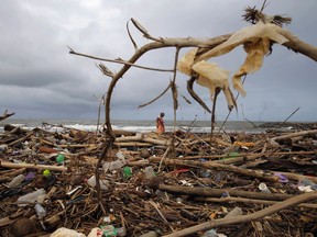 A Sri Lankan ragpicker searches for plastic waste washed ashore on the promenade of the Indian ocean in Colombo, Sri Lanka, Monday, June 4, 2018. This year's World Environment Day theme, marked on June 5, is "Beat Plastic Pollution."