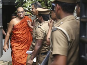 Galagoda Atte Gnanasara, leader of the Bodu Bala Sena or Buddhist Force is escorted by prison officials after he was sentenced to imprisonment by a magistrate court in Homagama, Sri Lanka, Thursday, June 14, 2018. The Sri Lankan court sentenced the controversial hard-line Buddhist monk for six months rigorous imprisonment for threatening the wife of a missing journalist.