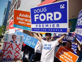 Political supporters rally on May 27, 2018, outside the CBC building in Toronto prior to a leaders' debate for the Ontario election.