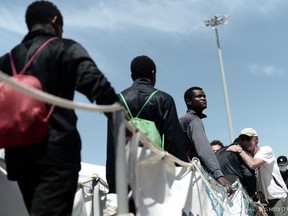 This photo released on Sunday, June 17, 2018, by French NGO "SOS Mediterranee", shows migrants disembarking the SOS Mediterranee's Aquarius ship and MSF (Doctors Without Borders) NGOs, after its arrival at the eastern port of Valencia, Spain. Ships in the Aquarius aid convoy docked Sunday at the Spanish port of Valencia, ending a week long ordeal for hundreds of people who were rescued from the perilous Mediterranean only to become the latest pawn in Europe's battle over immigration.