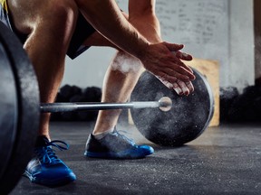 Closeup of weightlifter clapping hands before  barbell workout a