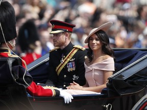 Britain's Prince Harry, left, and Meghan, Duchess of Sussex ride in a carriage to attend the annual Trooping the Colour Ceremony in London, Saturday, June 9, 2018.