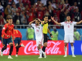 Moroccan players bemoan referee Ravshan Irmatov's decision to award Spain a late goal on the basis of video review at the World Cup on June 25.