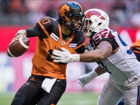 B.C. Lions quarterback Jonathon Jennings, left, is pressured by Montreal's Woody Baron during the first half of a CFL football game in Vancouver on Saturday, June 16, 2018.