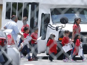 In this June 21, 2018, photo, migrant children walk off a bus at the Catholic Charities' Msgr. Bryan Walsh Children's Village in Cutler Bay, Fla. Congresswoman Debbie Wasserman Schultz said Monday, June 25, that children who range in age from newborns to 5 years old are being sheltered at this facility and His House Children's Home in Miami Gardens.