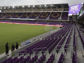 Police officers check to see that fans leave their seats to seek shelter during a weather delay before an MLS soccer match between Orlando City and the Montreal Impact, Saturday, June 23, 2018, in Orlando, Fla.