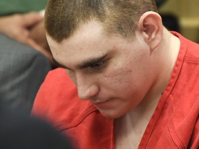 FILE - In this June 8, 2018 file photo, school shooting suspect Nikolas Cruz sits in the Broward County courthouse in Fort Lauderdale, Fla.  A freshman at Marjory Stoneman Douglas High School told investigators he encountered the shooting suspect in a stairwell as he was loading his AR-15 rifle and was told, "you better get out of here," according to police interview transcripts released Friday, June 22, 2018. The student's account is part of the prosecution's case against Cruz, who is charged with 17 counts of first-degree murder and 17 counts of attempted murder in the Valentine's Day massacre in Parkland, Fla.