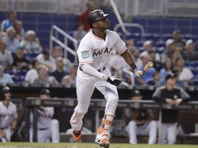 Miami Marlins' Lewis Brinson hits a sacrifice fly to score Starlin Castro to tie the game during the ninth inning of a baseball game against the San Francisco Giants, Thursday, June 14, 2018, in Miami. The Giants won 6-3 in 16 innings.