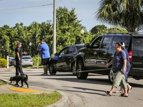 An Orlando Police officer checks the ID of residents trying to enter the Westbrook Apartments in Orlando, Fla., on Tuesday, June 12, 2018. Four young children were discovered dead at the west Orlando apartment complex late Monday, nearly 24 hours after a standoff that began when an Orlando police officer was shot responding to a domestic violence call.