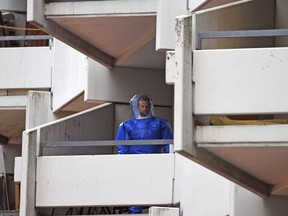 FILE - In this June 15, 2018 file photo a German police officer in protective gear walks down stairs in an apartment building at Osloerstrasse 3, in Cologne, Germany, after confiscating toxic substance at an apartment of an 29 years old Tunisian man in the complex on Tuesday. German security officials say a call from the public helped foil an Islamic extremist's plan to use the toxin ricin to carry out a deadly attack.