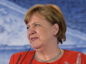 German Chancellor Angela Merkel grimaces at a press conference with France's President Emmanuel Macron after a meeting in the guest house of the German government in Meseberg north of Berlin, Germany, Tuesday, June 19, 2018.