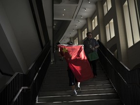 FILE - In this Wednesday, June 20, 2018 file photo, a soccer fan from China carries his national flag as the walks inside the Luzhniki Stadium during the group B match between Portugal and Morocco at the 2018 soccer World Cup in Moscow, Russia. Chinese sponsors are more visible than ever and tens of thousands of Chinese fans have descended on Moscow, using their growing economic clout to secure top-dollar seats and dreaming of the day, perhaps not that far off, when China will host football's showcase.